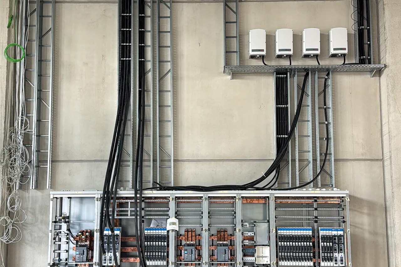 Elektrische Geräte und Kabeltrassen während der Montage in einer Gewerbehalle
